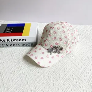 Detail of beige lace mesh baseball cap with pink diamond patterns and rhinestone butterflies