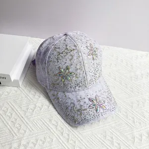 Détail d'une casquette de baseball en dentelle violet clair avec fleurs en strass