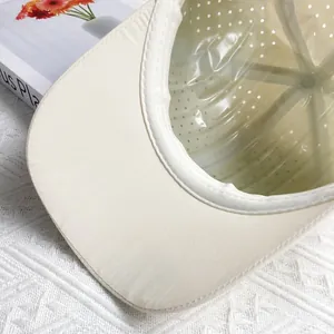 Detailed interior of a beige quick-dry baseball cap with mesh holes and fine stitching