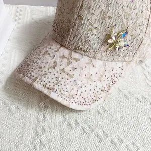 Detailed close-up of lace baseball cap with crystal rhinestones and maple leaf brooch
