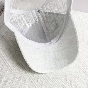 Detail view of white floral lace fabric and breathable structure on fashion baseball cap