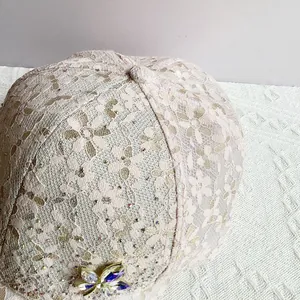 Detailed macro view of pink floral lace baseball cap with sparkling crystal butterfly charm