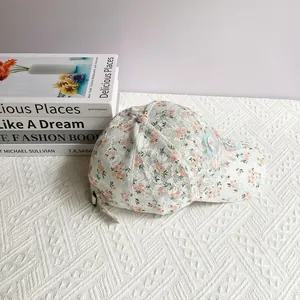 Détail de la casquette en dentelle florale blanche avec fleurs 3D et cristaux chic