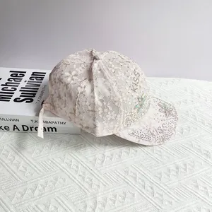 Détail de la casquette rose en dentelle avec strass brillants et motifs floraux brodés