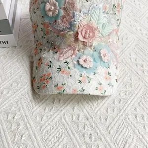 Gros plan sur la casquette en dentelle blanche avec fleurs 3D faites main et perles