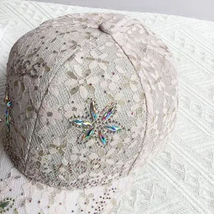 Vue détaillée d'une casquette de baseball en dentelle rose avec des fleurs en strass brillant