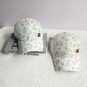 Detailed close-up of floral lace baseball cap with 3D cherry pendants and floral embroidery