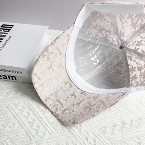 Gros plan sur la dentelle florale et le mesh respirant de la casquette beige chic