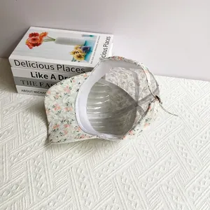 Detailed macro view of the floral lace baseball cap with metal buckle on knit desk