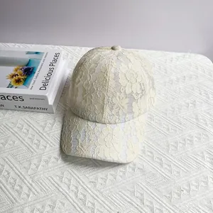Détail de la dentelle florale élégante et du filet respirant sur la casquette ivoire