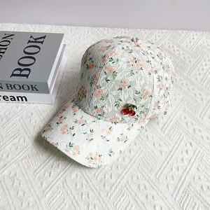 Close-up of floral lace baseball cap featuring a 3D cherry rhinestone decoration