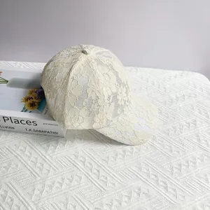 Détail d'une casquette beige avec broderie en dentelle florale et texture respirante