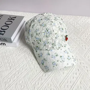 Close-up of delicate lace floral pattern and cherry pin accessory on sun baseball cap