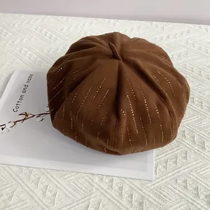 Detail of brown wool newsboy cap featuring vertical sparkling rhinestone embellishments