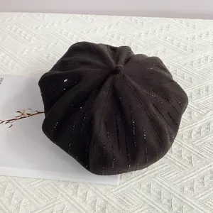 Detailed close-up of a black wool beret featuring vertical rows of shimmering rhinestones