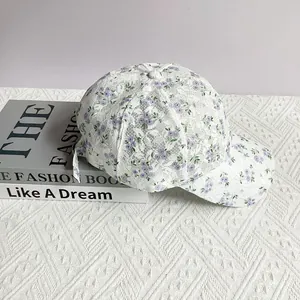 Detail of floral lace mesh on white baseball cap with small purple flower patterns
