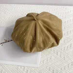 Detail of light brown wool beret featuring silver rhinestones and classic top stem design