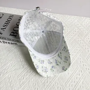 Detail view of floral lace baseball cap with purple cherry print and breathable texture