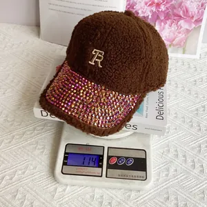 Detail of brown faux shearling baseball cap with golden TR embroidery and rhinestone brim