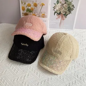 Dettaglio dei cappellini in lana di agnello con visiera di strass e ricamo