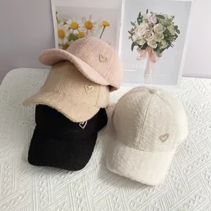 Détail de casquettes en peluche d'alpaga avec emblème cœur strass en quatre couleurs douces