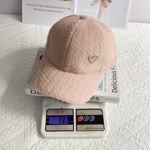 Casquette en laine d'alpaga rose avec cœur en strass sur une balance numérique