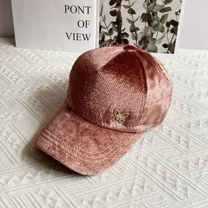 Dettaglio del cappellino in velluto rosa con decorazione a farfalla di cristallo