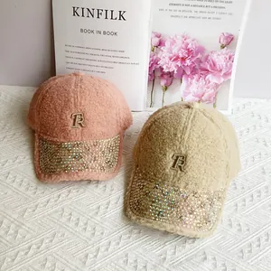 Close-up of pink and beige fleece baseball caps with rhinestone brims and TR metal embroidery