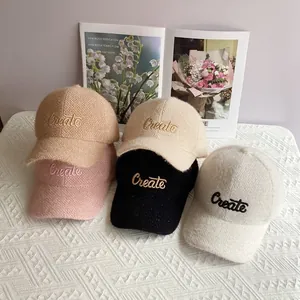 Dettaglio dei berretti da baseball in ciniglia con ricamo 'Create' in cinque colori neutri