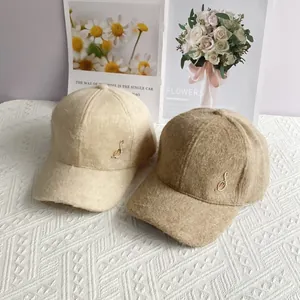 Detailed close-up of velvet baseball caps with rhinestone musical note metal badges