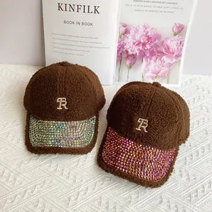 Close-up of sherpa baseball cap with rhinestone brim and golden TR metal logo