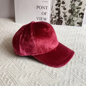 Dettaglio del cappellino da baseball in velluto bordeaux con trama a coste e visiera cucita