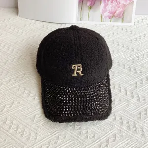 Detailed view of the black fleece baseball cap with sparkling rhinestones and gold TR logo