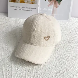 Gros plan sur la casquette en laine d'alpaga blanche avec texture pelucheuse et cœur doré