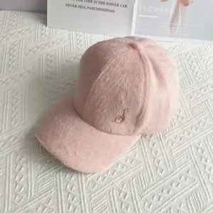 Detailed view of pink plush velvet baseball cap with gold musical note emblem