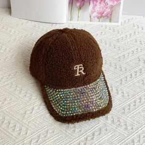Detail of brown teddy fleece baseball cap with sparkling rhinestones and metal TR logo