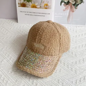 Dettaglio del berretto in pile kaki con ricamo e visiera decorata con strass