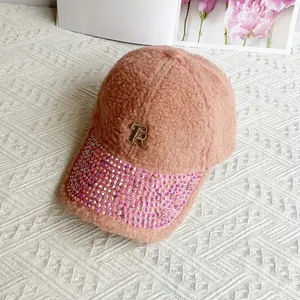 Detailed macro view of pink fuzzy baseball cap featuring rhinestone brim and metal R logo