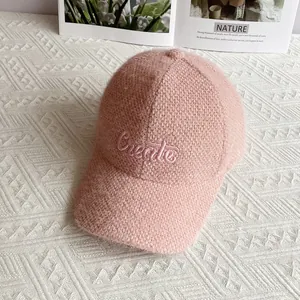 Dettaglio del berretto da baseball in ciniglia rosa con maglia morbida e ricamo di lettere