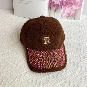 Detail of brown teddy fleece baseball cap with R embroidery and rhinestone brim