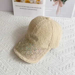 Dettaglio della tesa decorata con strass di un berretto da baseball in pile beige