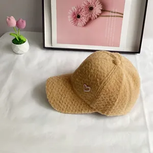 Détail d'une casquette en laine d'alpaga camel avec cœur en strass et texture douce