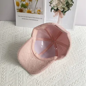 Detail of soft pink plush baseball cap interior showing smooth lining and warm texture