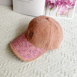 Detail of pink teddy fleece baseball cap with rhinestone brim and metal R logo