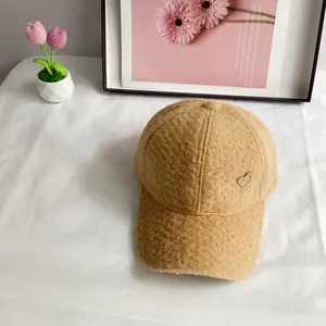 Détail de la casquette en polaire sherpa marron clair avec ornement de cœur en strass