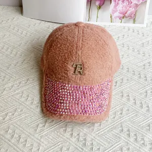 Detail of pink fleece baseball cap featuring rhinestone brim and gold TR embroidery