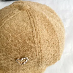 Détail de la casquette en velours d'alpaga camel avec décoration de cœur en strass