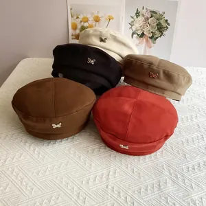 Detailed collection of wool berets in five colors featuring metallic butterfly accents