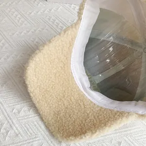 Dettaglio del cappellino beige in pile con texture morbida e cucitura interna rinforzata