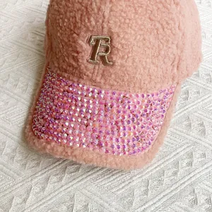 Close-up of pink faux shearling baseball cap with rhinestone brim and gold R embroidery